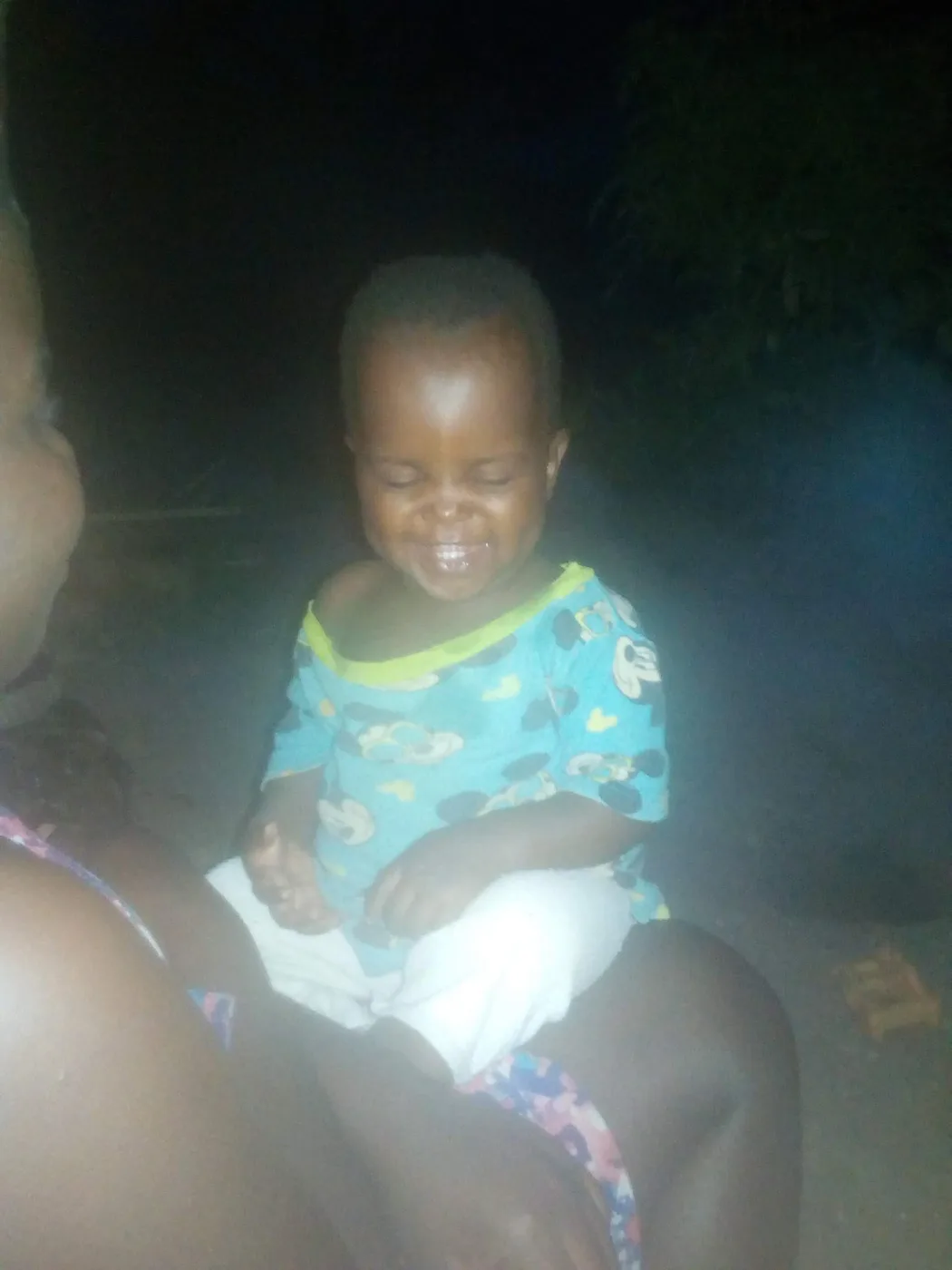 A baby smiling with eyes closed